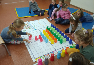 Dzieci układają piramidę żywienia z kolorowych kubeczków